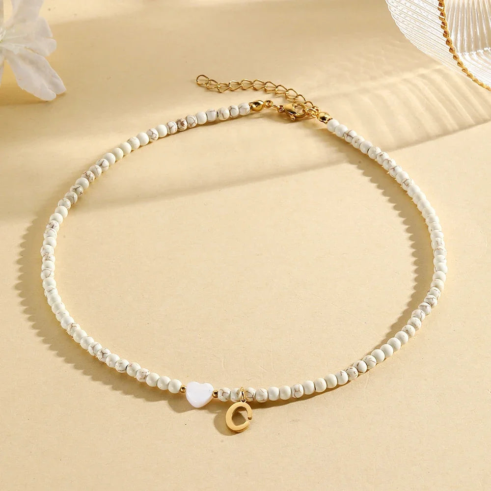 Choker boho con perline, cuore in conchiglia e iniziale in acciaio – collana personalizzata stile 2025