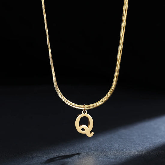 Collana iniziale A–Z in acciaio placcato oro con snake chain – pendente minimal su collare clavicolare