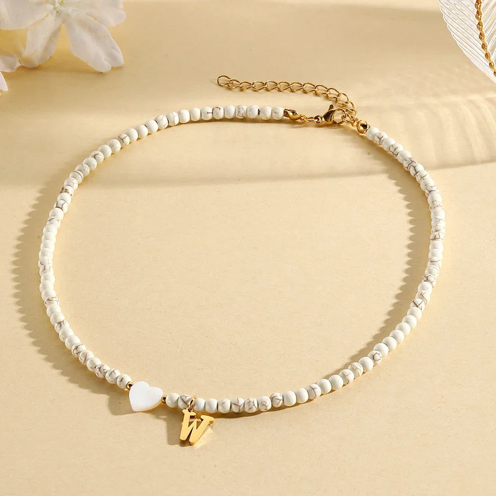 Choker boho con perline, cuore in conchiglia e iniziale in acciaio – collana personalizzata stile 2025