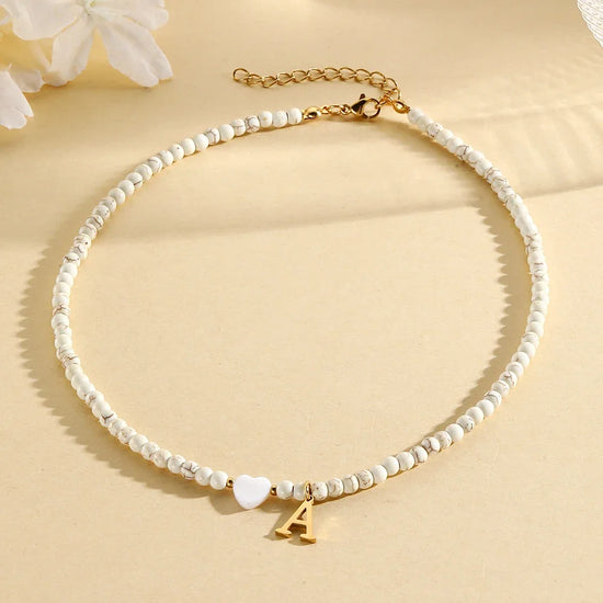 Choker boho con perline, cuore in conchiglia e iniziale in acciaio – collana personalizzata stile 2025