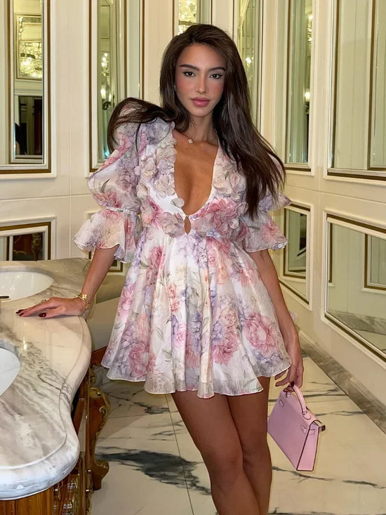 Donna elegante in abito mini chiffon floreale con scollatura a V e maniche a palloncino, perfetto per party estivi